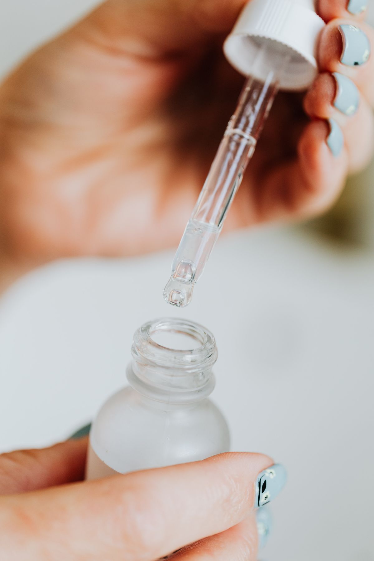 Cận cảnh bàn tay với lọ serum dưỡng da