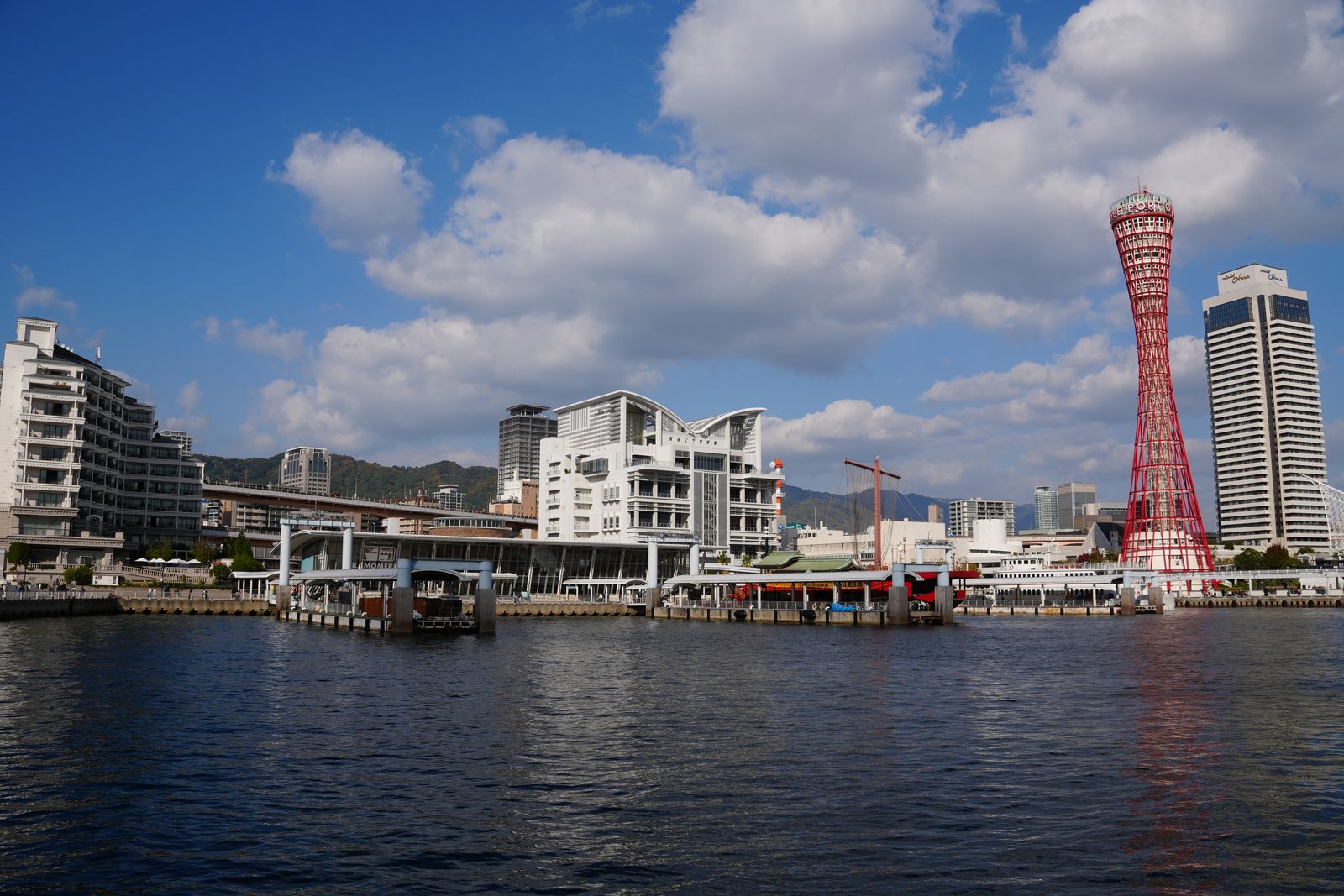 Tháp cảng Kobe màu đỏ bên bến Harborland dưới trời xanh nhiều mây trắng