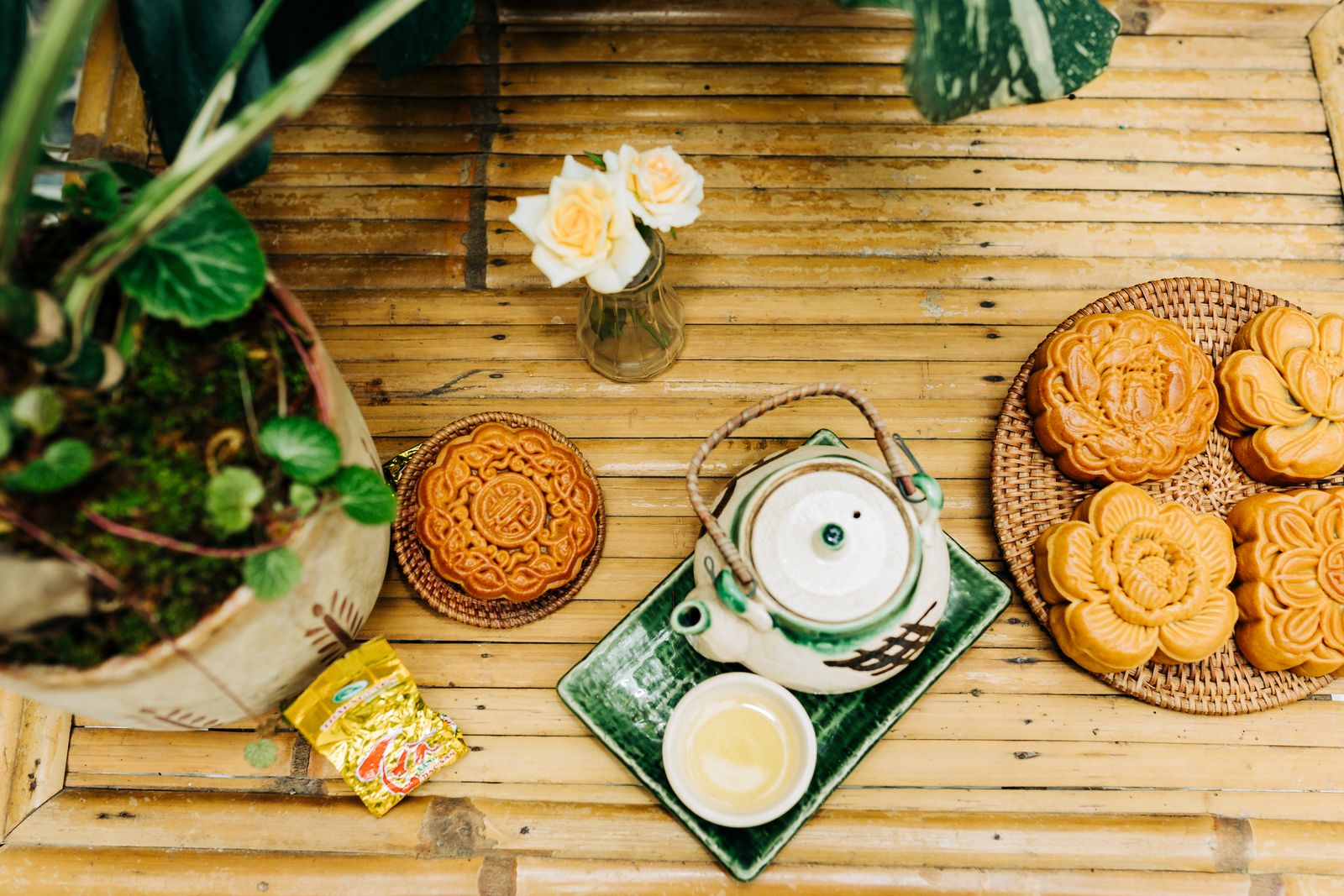 Bánh trung thu Việt Nam và bộ ấm trà bày trên bàn tre nhìn từ trên xuống