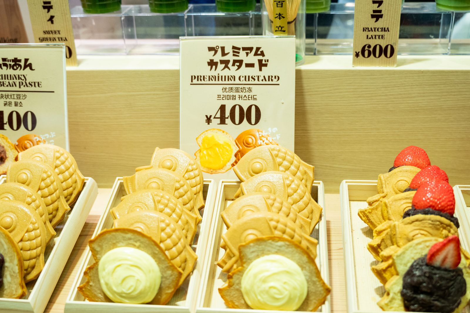 Quầy bánh taiyaki nhân kem trứng và đậu đỏ bày trong tủ kính một tiệm bánh Nhật