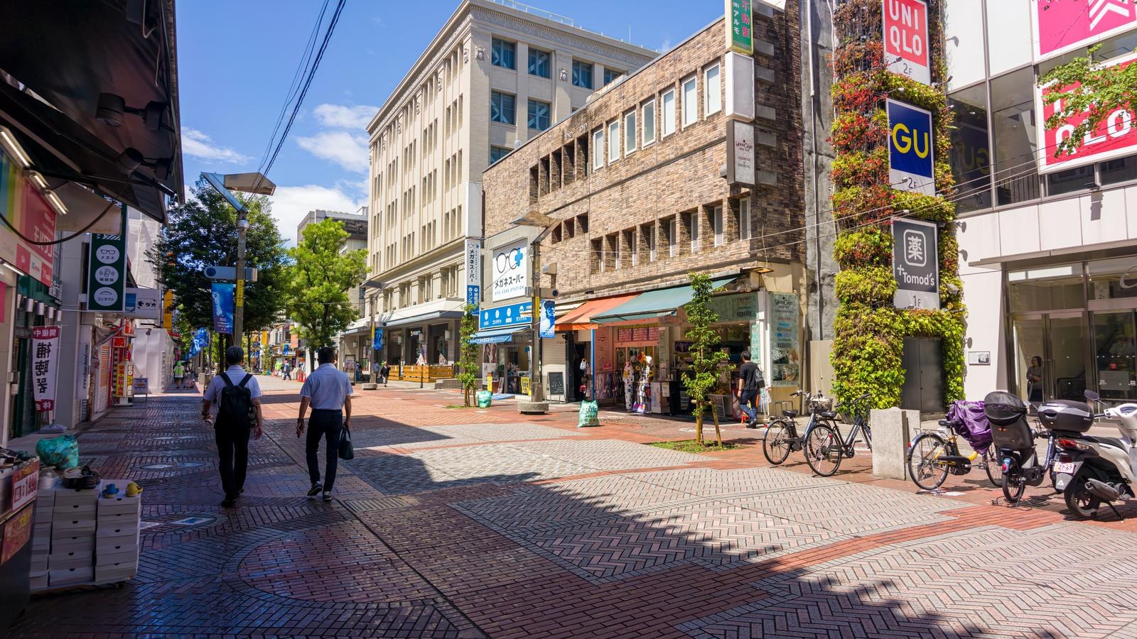 Biển hiệu UNIQLO và GU trên phố mua sắm Isezaki Mall ở Yokohama